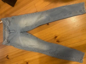 Ljusblå skinny jeans - Säljer ett par ljusblå skinny jeans från Vero Moda med klassisk femficksdesign. Jeansen har en snygg tvätt med lätt slitning på låren och är tillverkade i stretchigt denim för extra komfort.