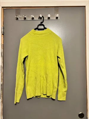 Ljusgrön ribbad tröja Cubus - Tröjan har ett ribbat mönster, långärmade ärmar och en rundad halsringning. Perfekt för dig som gillar färg och vill ha en skön och mjuk tröja till garderoben.