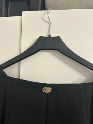 Svart blus med knyt från Chiara Forti - Supersnygg svart blus från Chiara Forti Milano i storlek XS. Blusen har långa puffärmar, v-ringad hals och ett brett knytband i midjan som ger en cool siluett. Materialet känns mjukt och har en lätt stretch. Perfekt för dig som gillar stilrena och trendiga plagg.