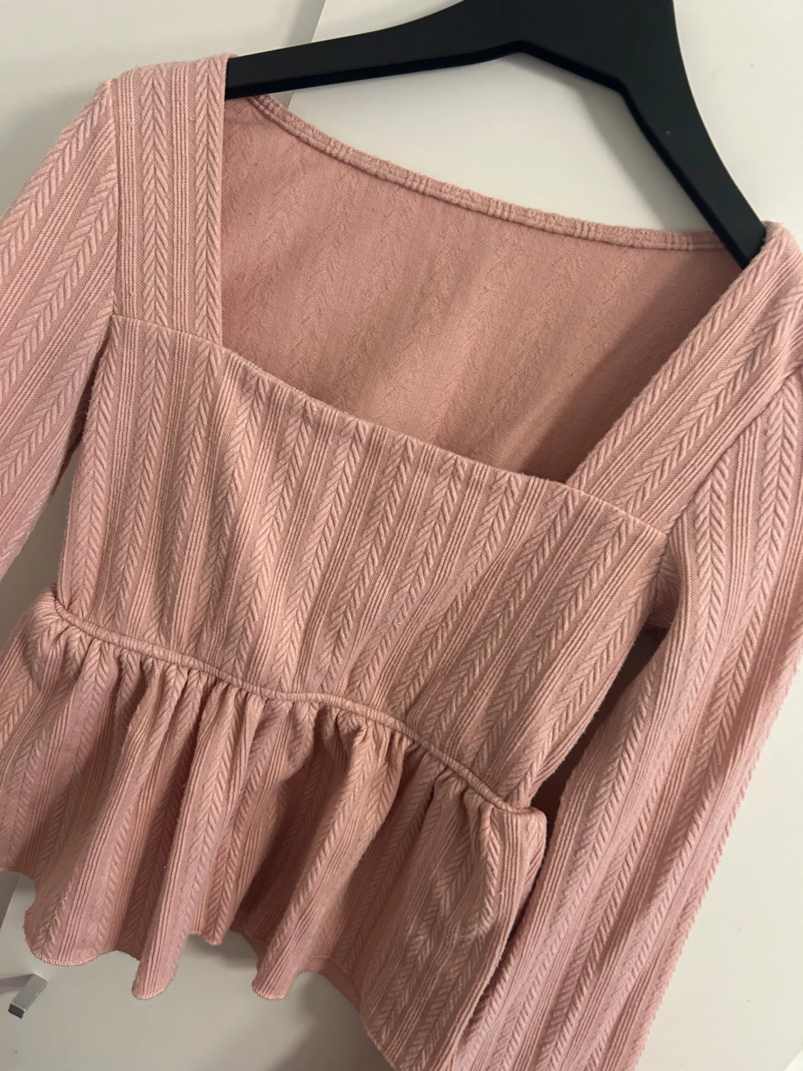 Ljusrosa ribbad blus med volang