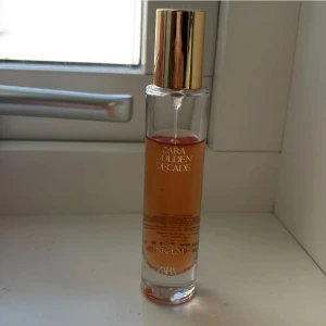 Zara Golden Decade parfym - Zara Golden Decade är en stilren parfym med modern känsla. Perfekt för dig som vill ha en trendig doft i din samling. Flaskan har en lyxig look med gulddetaljer. Volym och ingredienser framgår inte tydligt på bilden.