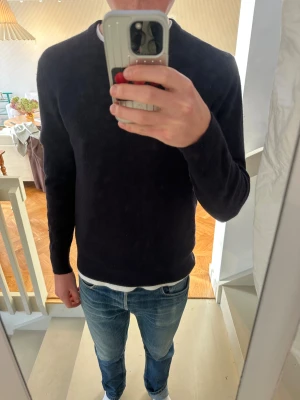 Mörkblå stickad Kashmirtröja - Snygg mörkblå stickad tröja från H&M med rund hals och ribbade muddar vid ärmslut. 100% Kashmir. Storlek M. Passar true to size. 