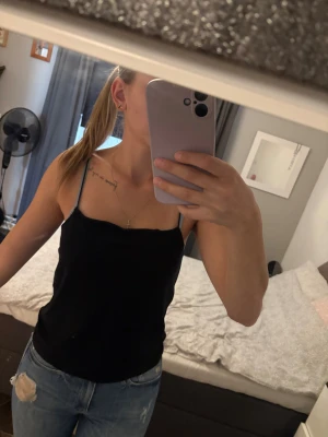 Linnen - Två stilrena linnen i svart och ljusblått med smala axelband. 