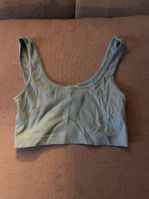 Ljusblå ribbad linnetopp - Säljer en ljusblå croppad linnetopp med breda axelband och rundad halsringning. Toppen är ribbad och har en mjuk, stretchig känsla som gör den superbekväm. Perfekt för dig som gillar enkel och stilren design. Pris kan alltid diskuteras 