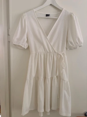 Superfin vit klänning - Supersöt vit klänning med snörning på midjan ifrån Gina som inte säljs längre. Perfekt till sommaren eller en sommaravslutning. 🌸mycket bra skick och passar både XS och S!