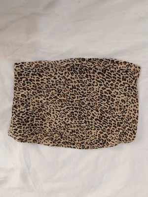Leopardmönstrad tubtopp från SHEIN - Tubtopp från SHEIN i storlek XS med leopardmönster. Väldigt croppad. Sparsamt använt!Katt finns I hemmet.
