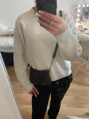 Svart axelväska i mocka från Zara - Säljer en svart axelväska från Zara i mocka med silverfärgade nitar och dragkedja upptill. Väskan har justerbart axelband och kedjedetalj på ena sidan. Köpt 2023 inte använd så mycket. Täcken på användning genom rost på visss ställen men det syns inte. Därav säljs den billigt