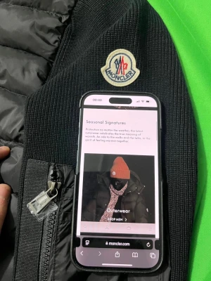 Svart cardigan från Moncler - Snygg svart cardigan från Moncler med stickade ärmar och huva. Jackan har dragkedja framtill, fickor med dragkedja och en Moncler-logga på ärmen. Materialmix av polyester och stickad bomull ger både värme och stil. Perfekt för kyliga dagar.