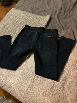 Mörkblå jeans Nudie Jeans - Säljer ett par mörkblå jeans från Nudie Jeans i modellen 32/34. Modellen är lean Dean