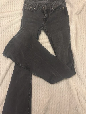 Svarta bootcut jeans från 157 - Säljer ett par svarta bootcut jeans från 157 med klassisk femficksmodell och låg midja. Jeansen har en snygg tvättad look och är tillverkade i mjukt jeansmaterial. Perfekta för dig som gillar en retro vibe och vill ha ett par riktigt schyssta byxor.