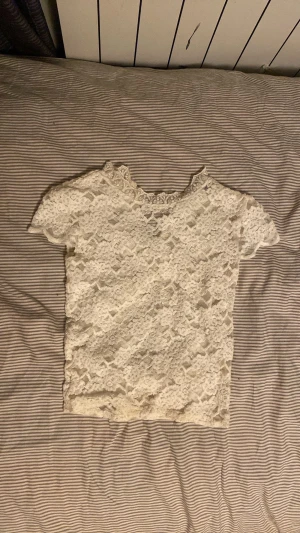 Vit spetsblus med kort ärm från Zara - Säljer en söt vit blus i spets med korta ärmar och rundad hals. Hela toppen är täckt av ett blommigt spetsmönster som ger en romantisk vibe. Perfekt att styla med jeans eller kjol för en fräsch look.