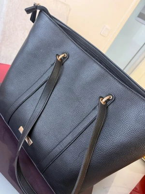 Svart axelväska från CHIARA F. - Stilren svart axelväska från CHIARA F. i strukturerat skinnimitation. Väskan har långa axelband, guldfärgade metalldetaljer och dragkedja upptill. Perfekt storlek för att få plats med allt du behöver och passar till många olika looks.