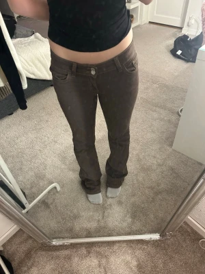 Bruna bootcut jeans  - Säljer ett par bruna jeans med bootcut-modell och snygga kontrastsömmar från NELLY som aldrig har används. Byxorna har låg midja, klassiska fem fickor och detalj på bakfickan. Nypris:700kr men pris kan diskuteras