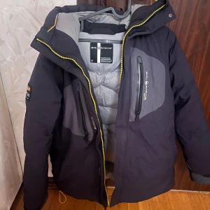 Svart dunjacka från Save The Duck - Säljer en svart dunjacka från Sail racing och med flera dragkedjeförsedda fickor. 