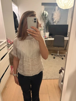 Vit hål mönstrad topp - Vit T-shirt likande topp med mönstrade hål. Lite smink defekter runt halsen som knappt syns.