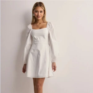 Vit klänning med långa ärmar - Stilren klänning som passar perfekt för studenten. Köpt från Nelly och har bara använts en gång. Storlek M (skulle säga att den är liten i storleken så passar någon som vanligtvis brukar ha S).