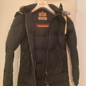 Svart dunjacka från Parajumpers - Säljer en svart dunjacka från Parajumpers med en lyxig pälsdetalj runt huvan. Inga skador på jackan, som ny.  Pris kan diskuteras vid snabb affär. Finns i Sollentuna. Storlek XXS (som XS)