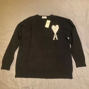 Svart stickad tröja från Ami Paris - Helt ny har aldrig använt den alla lappar är kvar och påsen. Snabb frakt. Inga hål eller fläckar eller annat tecken på användning. Perfekt inför vintern nu varm och skön.