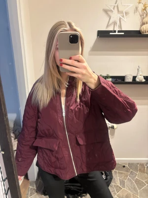 Quiltad vinröd jacka från H&M Divided - Quiltad jacka från H&M Divided i vinröd färg. Modellen är loose fit med ribbad krage, två stora fickor framtill och dragkedja. Jackan har lång ärm och är tillverkad i polyester, perfekt för höst och vinter. Ansvöny ca5 ggr då den ej passar mig  nypris: 500kr