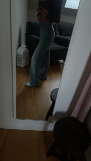 Blå bootcut jeans med hög midja - Snygga blå jeans med bootcut och hög midja, perfekta för dig som gillar en retro vibe. Jeansen har klassisk femficksdesign och är tillverkade i ett mjukt denimtyg som sitter skönt. Passar dig som vill ha en cool och avslappnad stil.