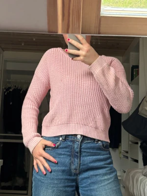 Rosa stickad tröja - Säljer en ljusrosa stickad tröja från Reserved med rund hals och ribbade muddar. Tröjan har en snygg, lite croppad passform och är långärmad. Perfekt att slänga på sig när det är lite kyligt ute. Passar dig som gillar mjuka och sköna plagg. Strl 146 men skulle säga att den passar XS!! Såå mysig, lite smutsig men tvättas självklart innan jag postar🫶🏽🫶🏽🫶🏽