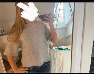 Grå stickad tröja med kort ärm - Mysig grå stickad tröja med korta ärmar och rund hals. Tröjan har en loose passform och ribbade detaljer vid hals, ärmslut och nederkant. Perfekt för dig som gillar enkel och stilren look. Använd fåtal gånger, skulle säga den är i nyskick☺️