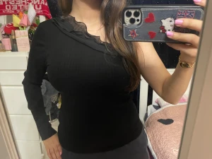 Amisu’s svart oneshoulder topp - Säljer en svart ribbad oneshoulder topp från Amisu med lång ärm och volangdetalj i mesh längs halsringningen. Snygg och unik design som sticker ut, perfekt för dig som gillar trendiga plagg med det lilla extra :)