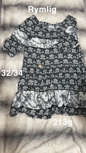 Svartvit mönstrad tunika 32/34 - Svartvit tunika från Vero Moda med unikt barockinspirerat mönster och volangkant nertill. Modellen är rymlig med trekvartsärm och resår vid halsen. Perfekt för dig som gillar statement-plagg med snygga detaljer.🌸 Fint använt skick. Rymlig. Storlek 32/34