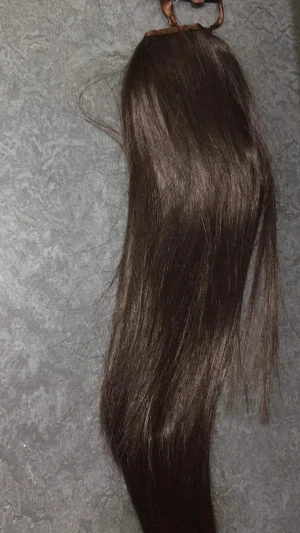 Mörkbrun clip-in hästsvans H&M - Snygg och lång mörkbrun clip-in hästsvans från H&M. Fästes enkelt med kam och brunt band för en naturlig look. Perfekt för att snabbt få längre och fylligare hår. Gjord i syntetmaterial med slät och glansig finish.