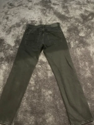 Svarta jeans från Jack & Jones - Säljer ett par svarta jeans från Jack & Jones, modellen Relaxed/Chris. Jeansen har klassisk femficksdesign, raka ben och normal passform. Materialet är slitstarkt denim och midjan är midwaist. Perfekt för dig som gillar en enkel och stilren look. Storlek 28 i midjan och 32 i längden 