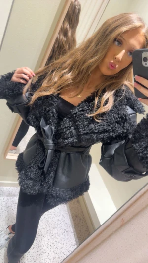 Bikbok Svart pälsjacka med skinn och bälte  - Säljer trendiga bikbok pälsjackan med knyte ! Köpt för 1 299kr ! 999kr kan jag sälja den för! 