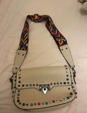 Valentino handväska! - En jättecool Valentino handväska med färgglada nitar. Man kan ta av axelbanden. Säljer billigt eftersom jag vill rensa ut❤️skinn material