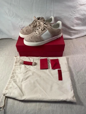 Valentino Rockrunner beige sneakers - Snygga Valentino Rockrunner sneakers i beige mocka med vita skinnpaneler och coola silverfärgade nitar på hälen. Platt sula med camouflage-mönster undertill och rund tå. Skorna har snörning och kommer med originalpåse och box. Skriv om ni har frågor o funderingar!😊