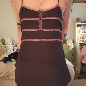 Lila topp - Lila topp med tunna axelband och dekorativa ljusrosa sömmar.