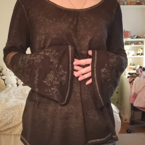 Svart tröja med broderade vida ärmar - Svart tröja med vida långärmar och broderade detaljer. Avslappnad passform.