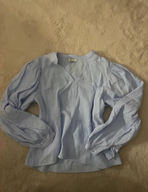 Blå blus - Snygg blå blus helt ny inte använda köpt i Varberg men kunde ej lämna tillbaka den därför säljs den NYPRIS: 399 Storlek är M men passar mig som är S