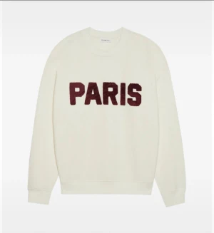 Vit sweatshirt med Paris-tryck - Vit sweatshirt från KnowledgeCotton Apparel med mörkrött Paris-tryck på bröstet. Tröjan har rund hals, ribbade muddar och långärmad passform. 