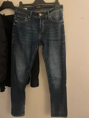 Blå slim fit  jeans från Jack & Jones - Snygga blå jeans från Jack & Jones i modellen 'slim Glenn'. Jeansen har klassisk femficksdesign, smal passform och är tillverkade i stretchigt denim för extra komfort. Perfekt för dig som gillar en modern och tajt look.