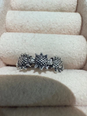 Silvrig ring med solblomsmotiv - Unik silvrig ring med tre detaljerade solblommor i rad. Ringen har en cool, bohemisk vibe och är gjord i metall med en antik finish. Perfekt för dig som gillar statement-smycken med naturinspirerade former.