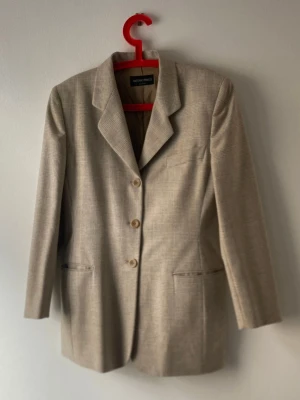 Vintage kostym Antonio Fusco Milano - Vintage tredelad kostym  Antonio Fusco Milano– kavaj, väst & byxor  Italiensk storlek 44 Elegant och tidlös tredelad kostym i 100% högkvalitativ ull. Passar perfekt för dig som uppskattar klassiskt snitt och exklusiva material. Tillverkad i Italien.  Plaggens mått (liggande, enkel mått) Kavaj: – Ärmlängd: 61cm – Rygglängd (mitt bak) 77cm – Bystvidd (halv omkrets) 50cm Byxor: – Midjevidd (halv omkrets) :37cm – Höftvidd (halv omkrets) : 50cm – Yttre bensöm (sidlängd) : 104cm – Innerbenslängd: 75cm