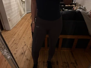 Mörkgrå leggings från ICANIWILL - Säljer ett par mörkgrå leggings från ICANIWILL med diskret logga på låret. De har en tight passform och är perfekta för träning eller chill. Materialet är stretchigt och följsamt för maximal komfort.