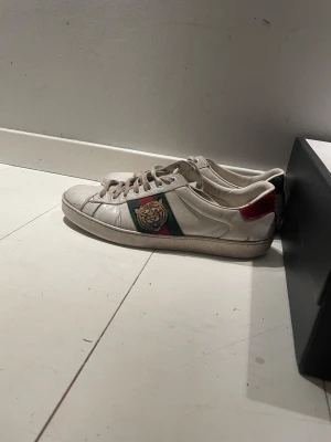 Gucci ace tigers skor - Gucci Ace tigers dojor i storlek 43(sicket är 8/10)plus att du får me Gucci box, Gucci dustbag och Gucci kort.ifall ni har några funderingar så är det bara att ställa det funderar över!