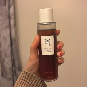 Beauty of Joseon Ginseng Essence Water - Ginseng Essence Water från Beauty of Joseon i en stilren, genomskinlig plastflaska med vit kork. Innehållet är brunt och flytande, perfekt för dig som vill boosta huden med fukt och näring. K-beauty favorit med ginsengextrakt för en fräsch och återfuktad känsla.