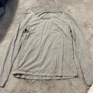 Ljusgrå långärmad tröja 157 - En enkel och stilren ljusgrå långärmad tröja från 157. Tröjan har rund halsringning och är gjord i mjuk bomullsmix som är skön mot huden. Passformen är normal och den är perfekt att ha som basplagg till olika outfits.