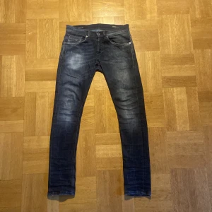 Mörkblå jeans från Dondup - Snygga mörkblå jeans från Dondup George i fit med klassisk femficksdesign och slitningar på låren. Jeansen har låg midja och är tillverkade i stretchigt bomullsmaterial för en tajt och bekväm passform. Perfekta för dig som gillar en smal siluett.