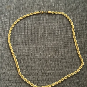 Guldigt Cornell halsband 60 cm 8mm - Snyggt halsband i guldton med tvinnad kedja och klassisk låsning. Kedjan har en cool, flätad design som ger extra edge till din stil. Perfekt för dig som gillar att sticka ut med accessoarer som syns. Ingen märkning synlig på bilderna.