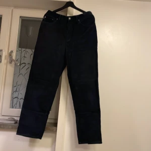 Svarta manchesterbyxor Lauren Jeans Co - Snygga svarta manchesterbyxor från Lauren Jeans Co med klassisk femficksdesign och raka ben. Byxorna har dragkedja och knapp framtill samt detaljerad etikett bak i midjan. Perfekta för dig som gillar en stilren och tidlös look.