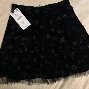  Ny Svart blommig sammetkjol med tyll - Supersnygg svart kortkjol från Bershka i mjuk sammet med diskret blommigt mönster. Kjolen har ett lager av tunn tyll längst ner som ger extra edge. Perfekt för dig som gillar detaljer och vill sticka ut lite extra. 
