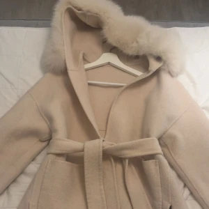Päls kappa - Beige kappa med päls, band i midjan. Går att ta av pälsen vid tvättning. Storlek xs🫶🏽