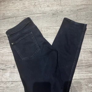 Mörkblåa jeans från 7 For All Mankind - Snygga mörkblåa jeans från 7 For All Mankind i klassisk femficksmodell. Jeansen har raka ben och normal passform, med diskreta sömmar och stilren look. Perfekta för dig som gillar en enkel och clean stil.